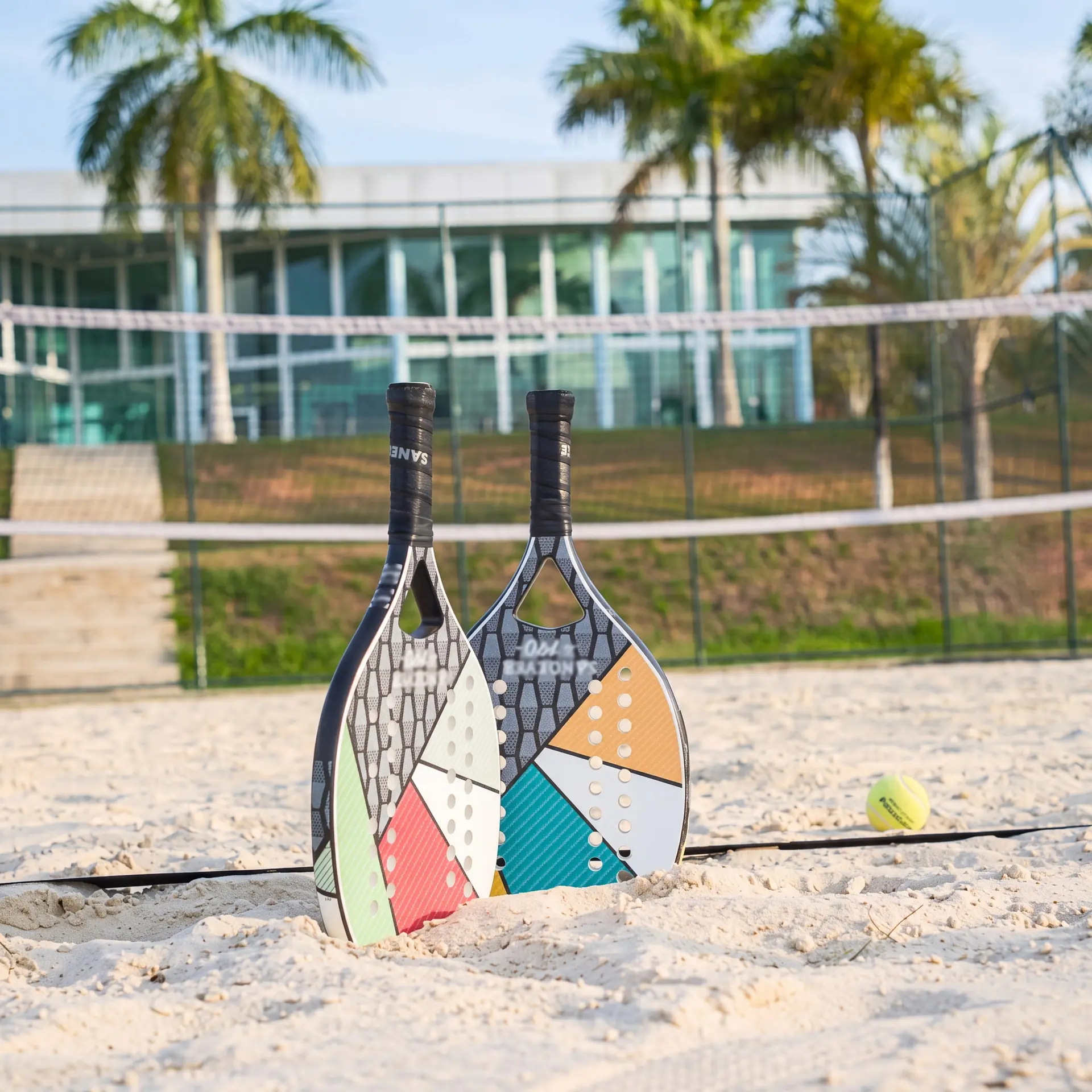 Quadra de beach tennis do Spa Recovery, com raquetes fincadas na areia e a rede ao fundo
