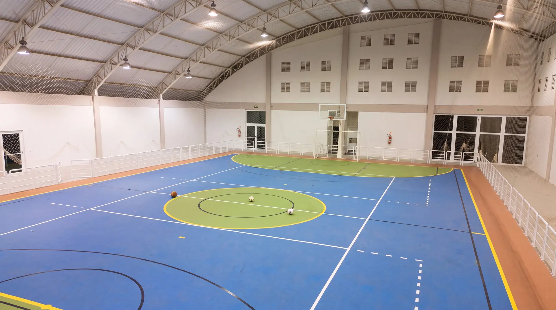Ginásio poliesportivo coberto do Spa Recovery, com quadra demarcada e cobertura em abóbada