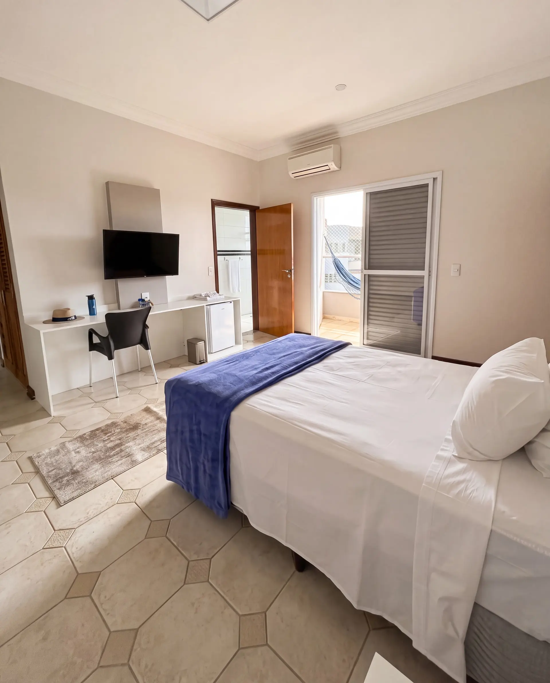 Suíte individual do Spa Recovery, com cama, escrivaninha e sacada